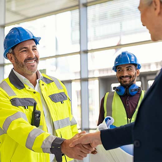 Contratista dándose la mano en el sitio de construcción