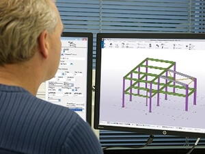 Steel estimator sat at computer using Tekla PowerFab