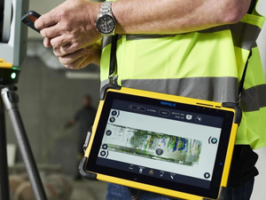 Bauingenieur kontrolliert Laserscanner-Daten auf Handy und Tablet